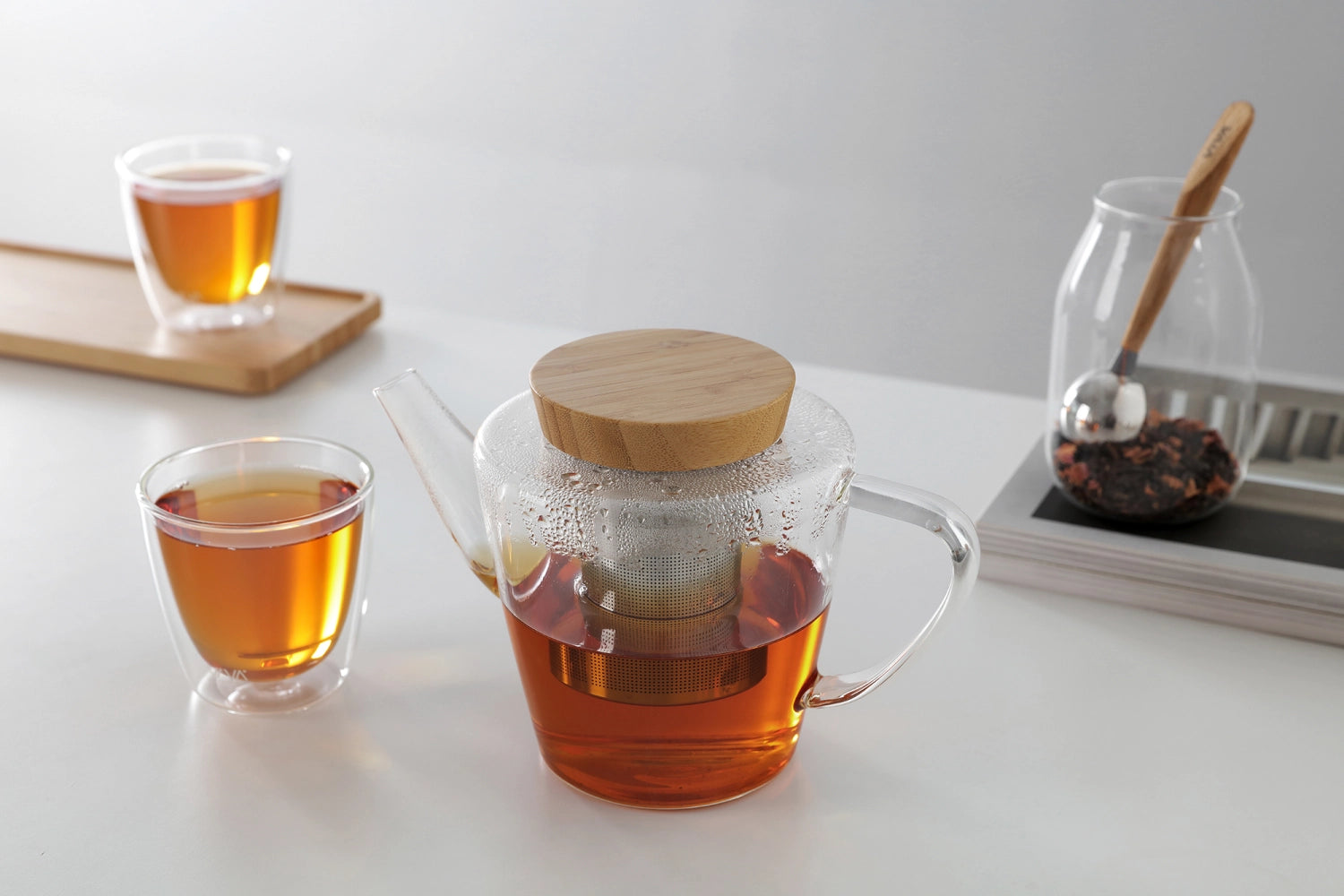 Eleganter Teekrug aus robustem Borosilikatglas mit einem natürlichen Holzdeckel, ideal für Teeliebhaber und stilvolle Teezubereitung.