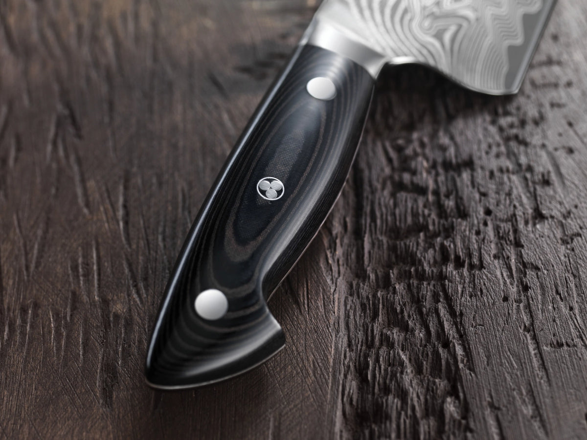 Foto des Zwilling Kramer Euro Stainless Spick & Garniermesser 9cm mit schwarzem Griff und Damaststahlklinge in charakteristischem Chevron-Muster.