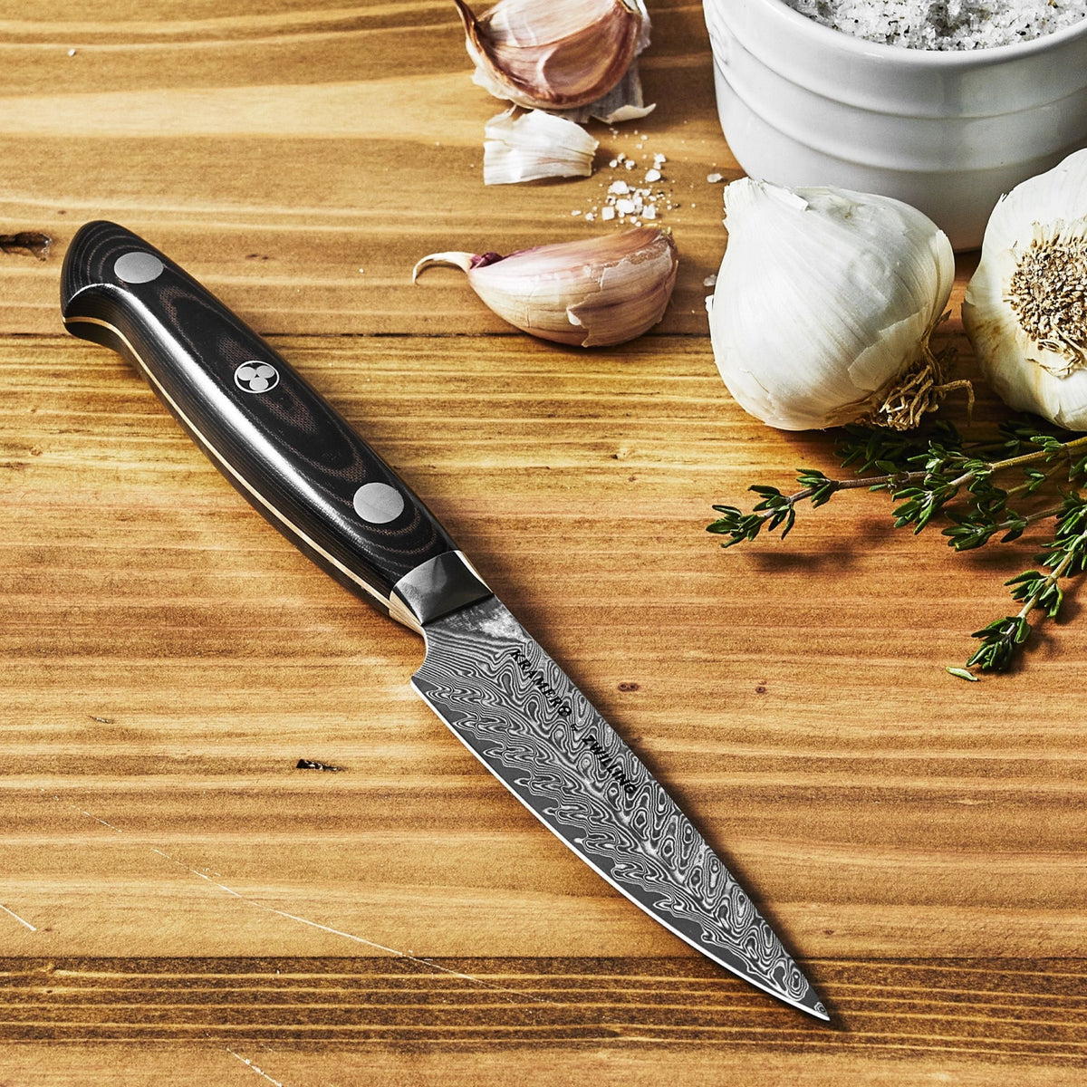 Küchenmesser von Zwilling mit 13 cm langer Damaststahlklinge, schwarzem Micarta-Griff und charakteristischem Mosaikstift am Griffende.