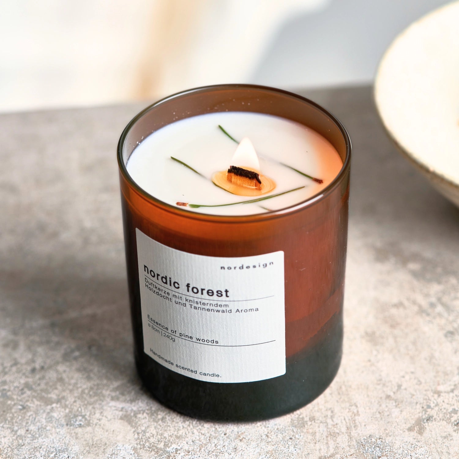 Elegante Duftkerze im Glas mit Holzdocht, die den beruhigenden Duft eines nordischen Waldes entfaltet und eine gemütliche Atmosphäre schafft.