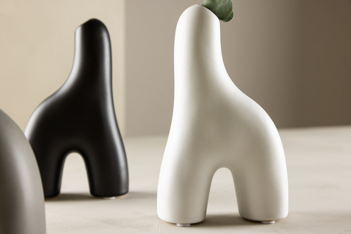 Weisse Vase Aya von Venture Home aus Steinzeug mit schlanker, eigenwilliger Form, freigestellt fotografiert.