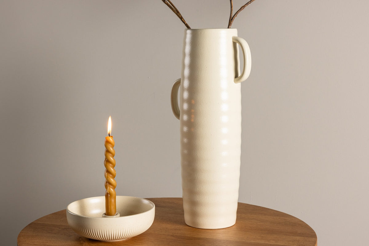 Beige Cent Vase von Venture Home aus Steinzeug mit wellenförmiger Struktur und zwei asymmetrisch angebrachten Griffen an den Seiten.