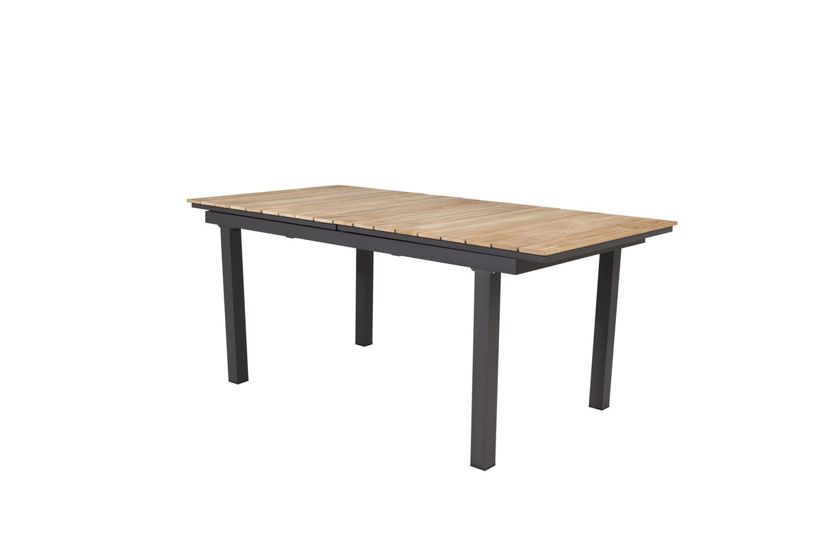 Rechteckiger Gartentisch Mexiko mit naturfarbener Teakholz-Tischplatte und schwarzem Aluminiumgestell, ausziehbar, im Freien aufgestellt.