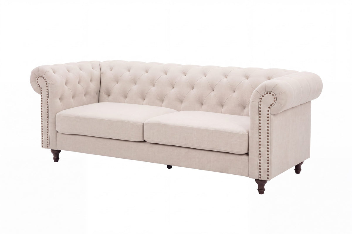 Beiges 3-Sitzer-Sofa Velvet von Venture Home mit Polyester-Samt-Bezug, tiefer Knopfheftung und schwarzen Gummibaumholz-Beinen im Chesterfield-Design.