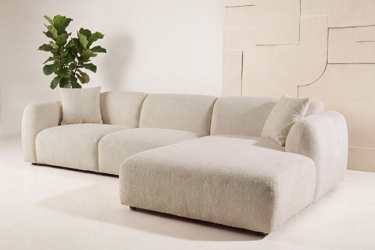 Beiges Chaiselongue-Sofa mit L-Form, Polyester-Bezug, schwarzen Holzbeinen und rechtsseitiger Chaiselongue, freigestellt fotografiert.