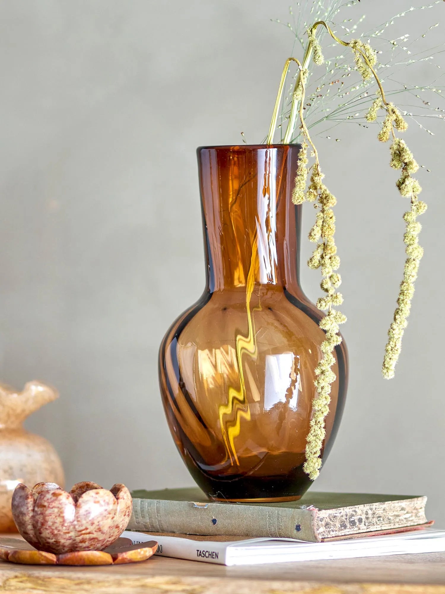 Die Saiqa Vase aus braunem Glas vereint Eleganz und Funktionalität, ideal für Blumenarrangements in jedem Wohnstil.