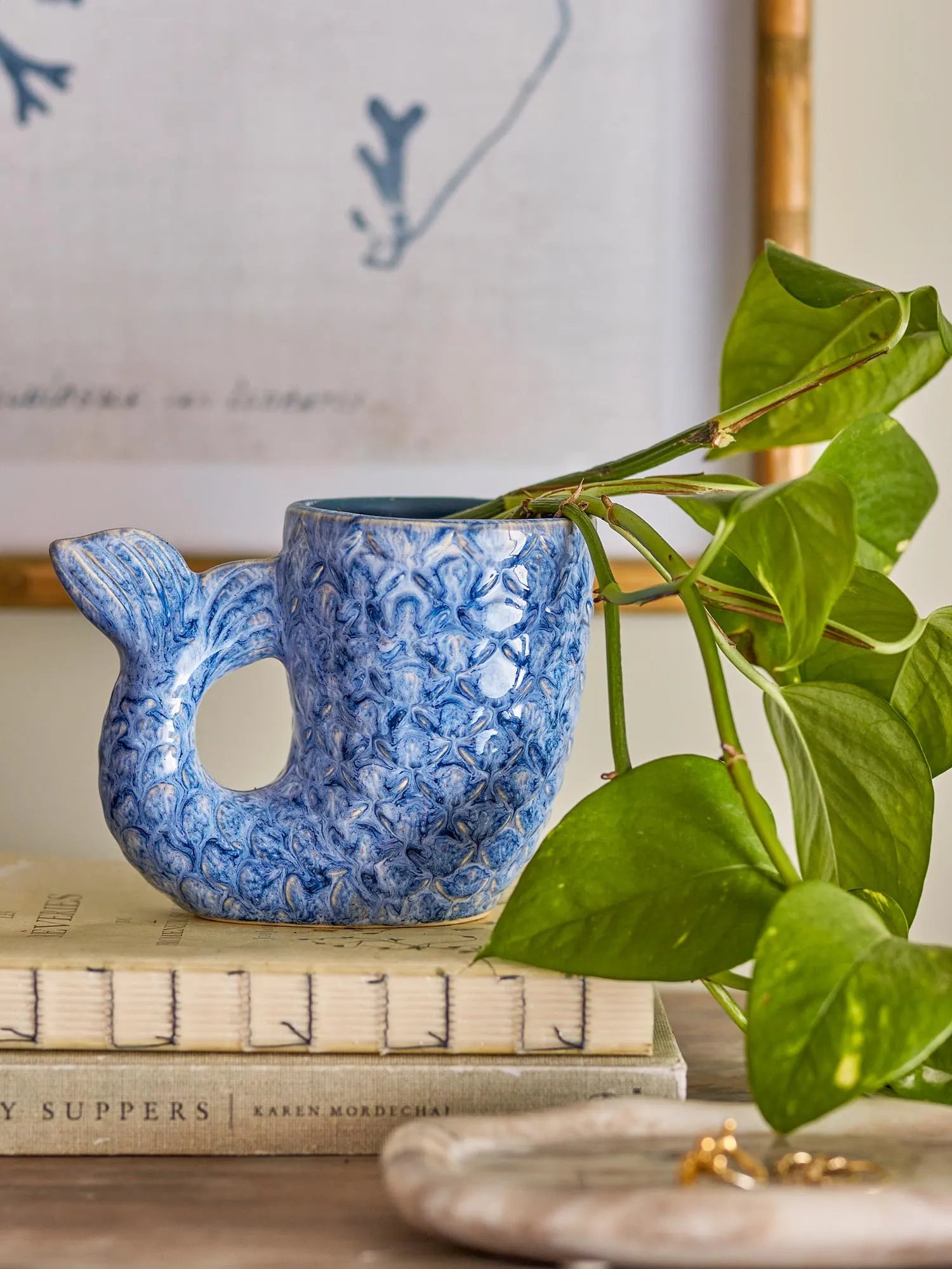 Die Ariella Vase in Blau, aus Steingut, besticht durch ihre muschelförmige Eleganz und die schimmernde, handgefertigte Glasur.