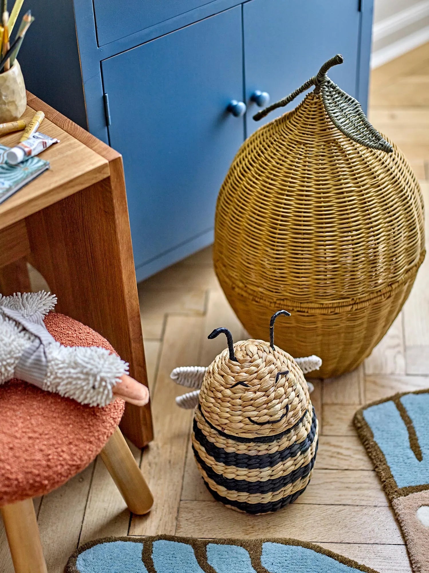 Ein fröhlicher, gelber Rattan-Korb mit Deckel, der an eine Zitrone erinnert, bringt Stil und Ordnung ins Kinderzimmer.