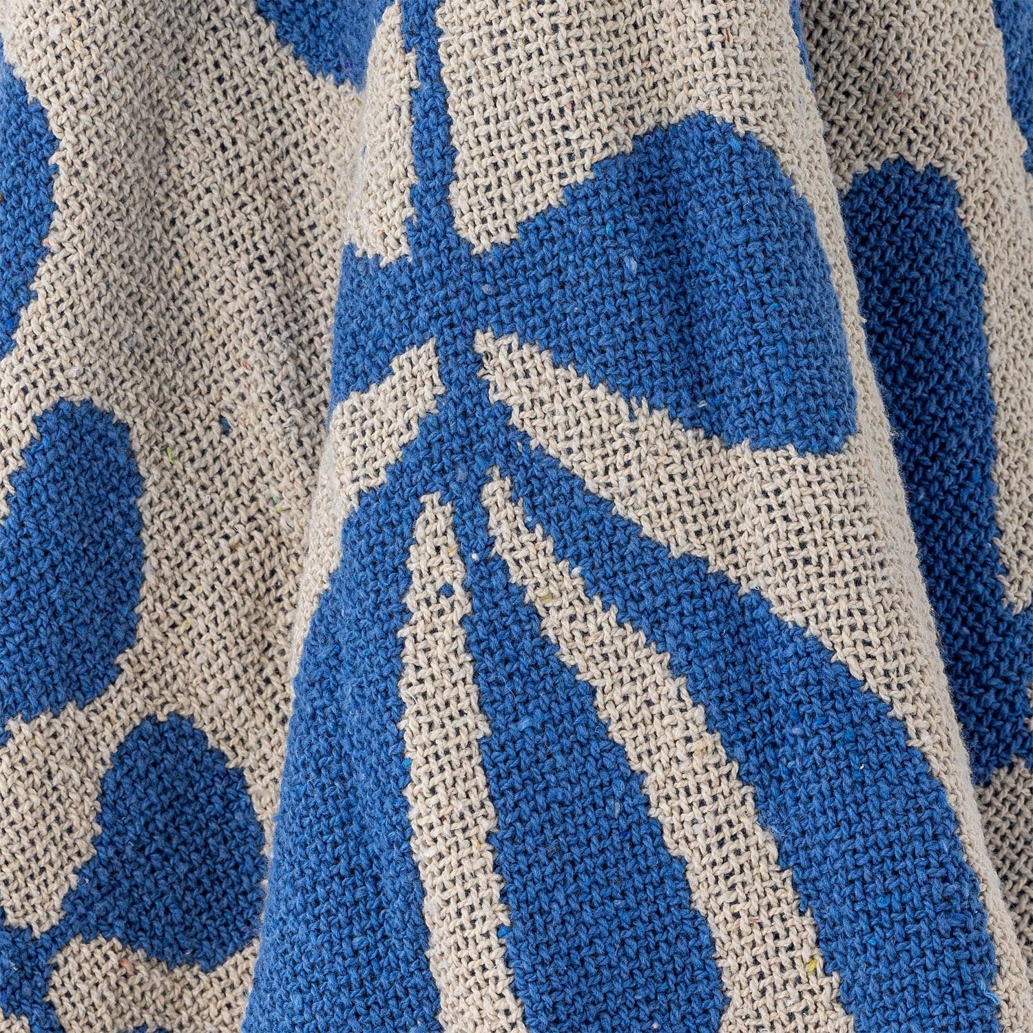 Die Nevine Decke von Bloomingville in Blau, gefertigt aus recycelter Baumwolle, vereint Nachhaltigkeit mit modernem Stil.