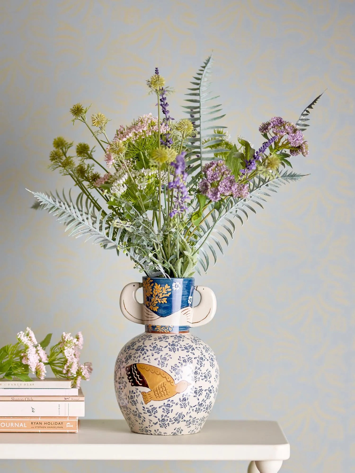 Die Hezha Vase von Bloomingville: Ein handdekoriertes Steingut-Kunstwerk mit Vogelmotiven in warmen Blau- und Brauntönen.