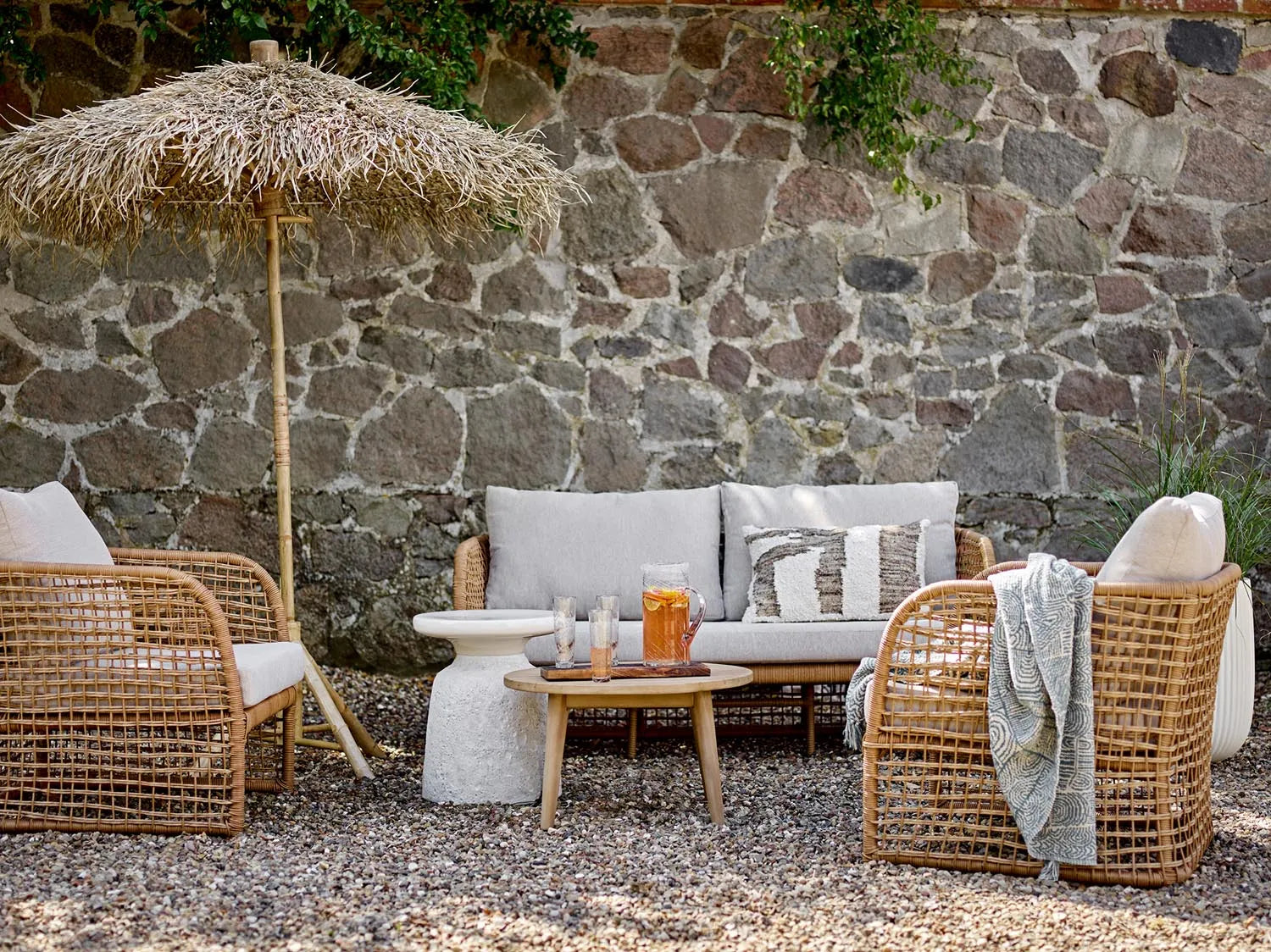 Eleganter Bambus-Sonnenschirm mit Palmblätterdach, bietet natürlichen Schatten und exotisches Flair für Ihren Garten.