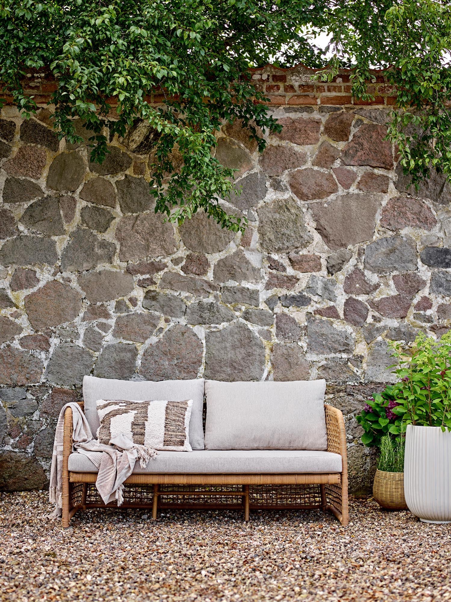 Das Penzano Sofa aus natürlichem Polyrattan von Bloomingville bietet stilvollen Komfort für drinnen und draußen.