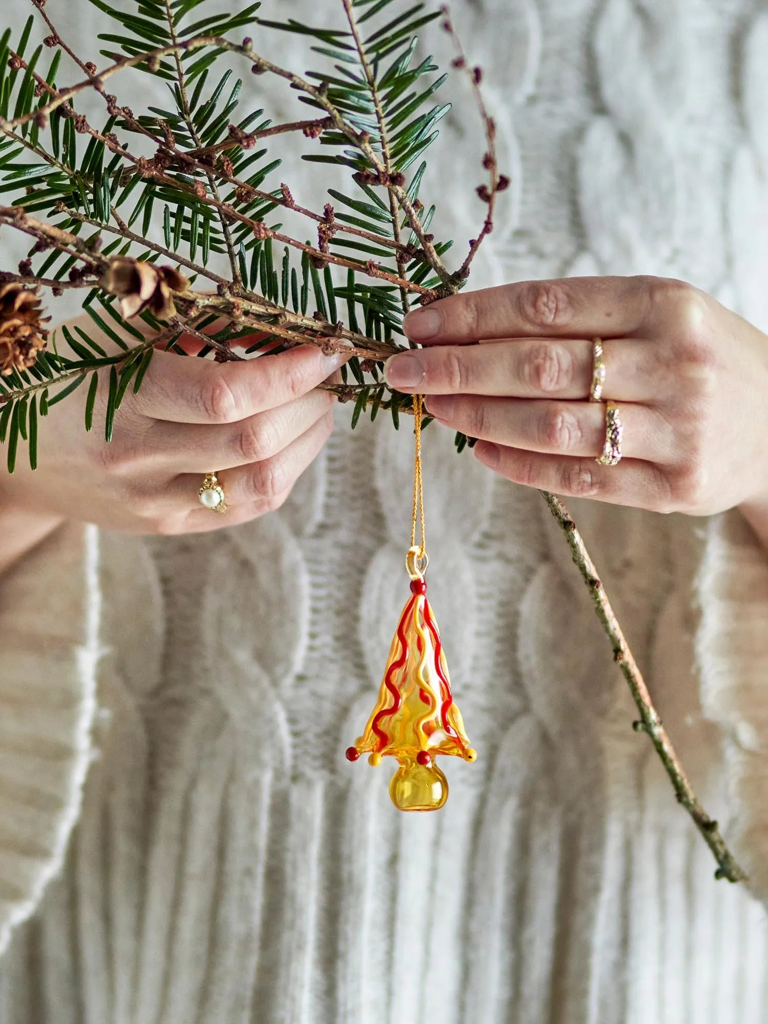 Ein leuchtend gelbes Glasornament mit kunstvollem Muster, handgefertigt und mundgeblasen, das Eleganz und Wärme in jeden Raum bringt.