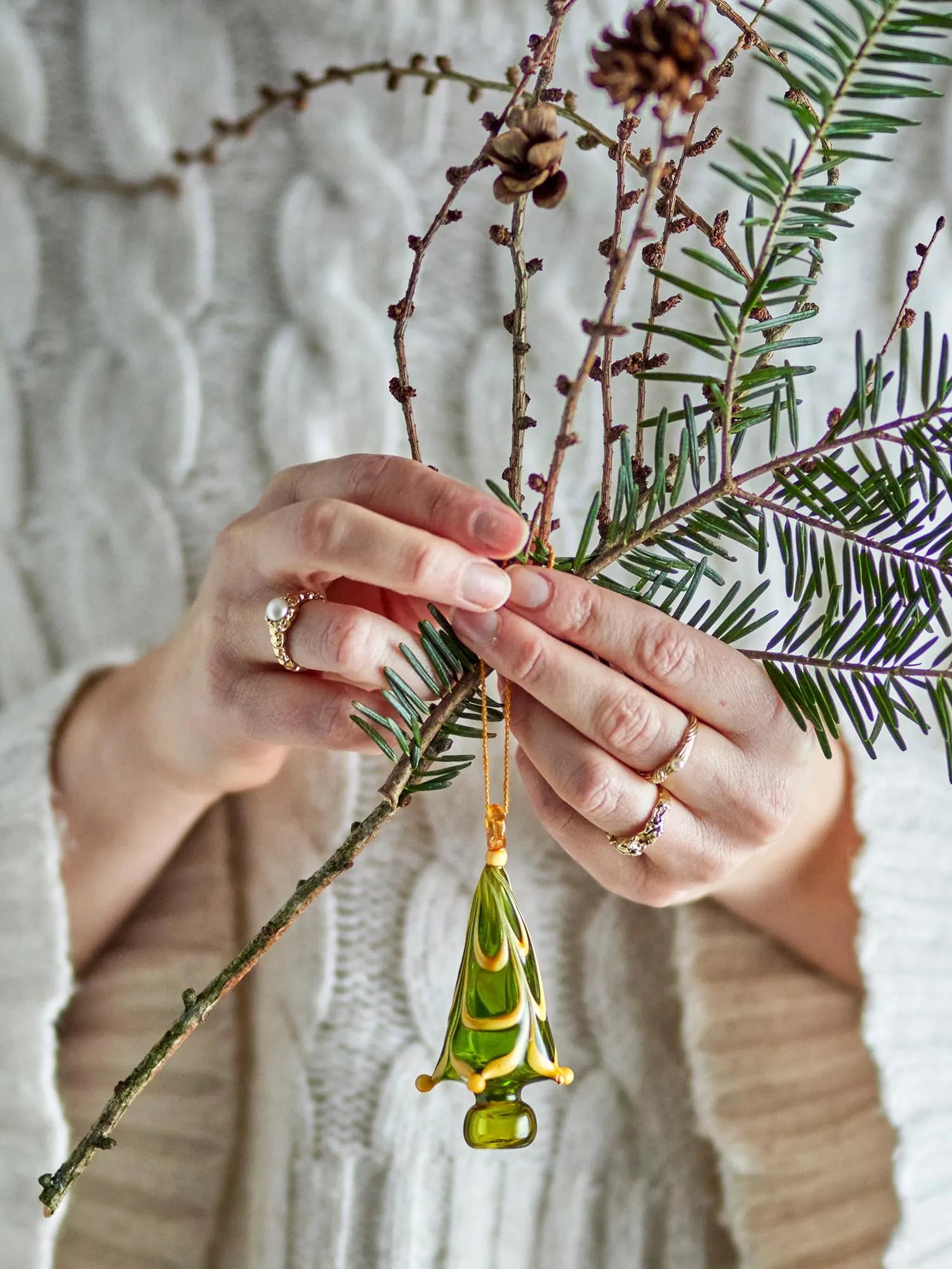 Ein handgefertigtes, grünes Glasornament mit gelbem Muster, das Eleganz und skandinavischen Charme ausstrahlt.