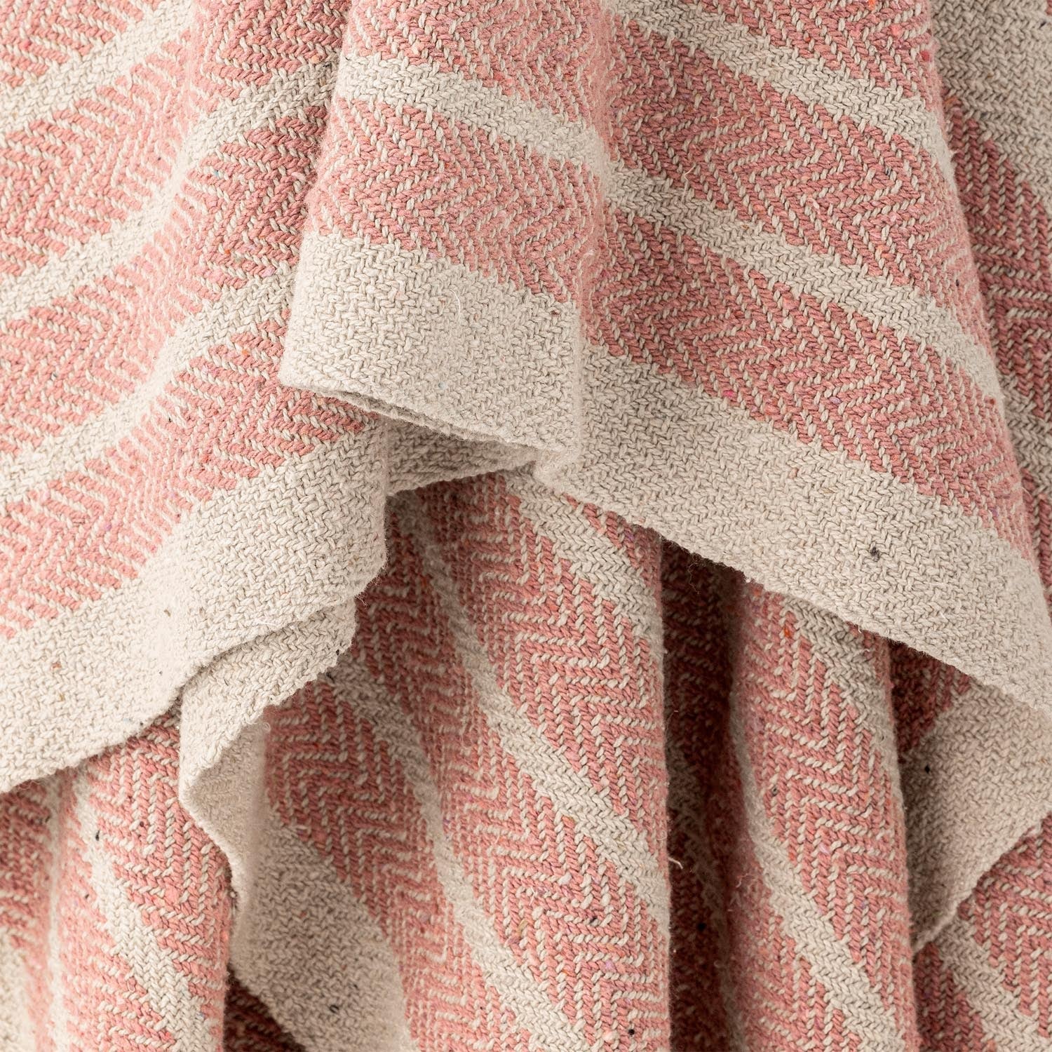 Die Monta Decke in zartem Rosé von Bloomingville aus recycelter Baumwolle vereint Nachhaltigkeit mit modernem Wohnstil.