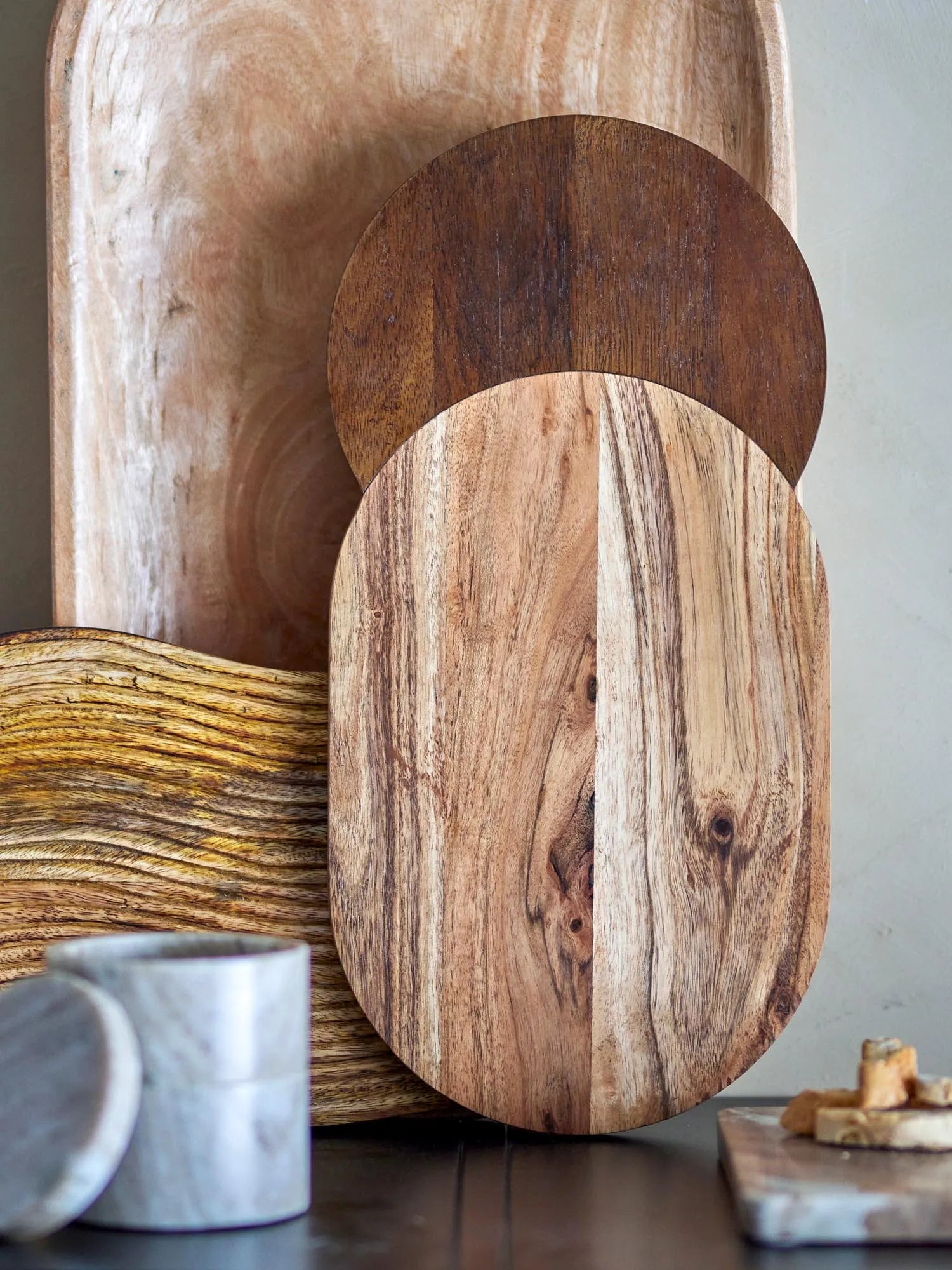 Elegantes Schneidebrett aus Mangoholz, das durch seine braunen Töne und runde Form besticht. Ideal für stilvolle Küchen.