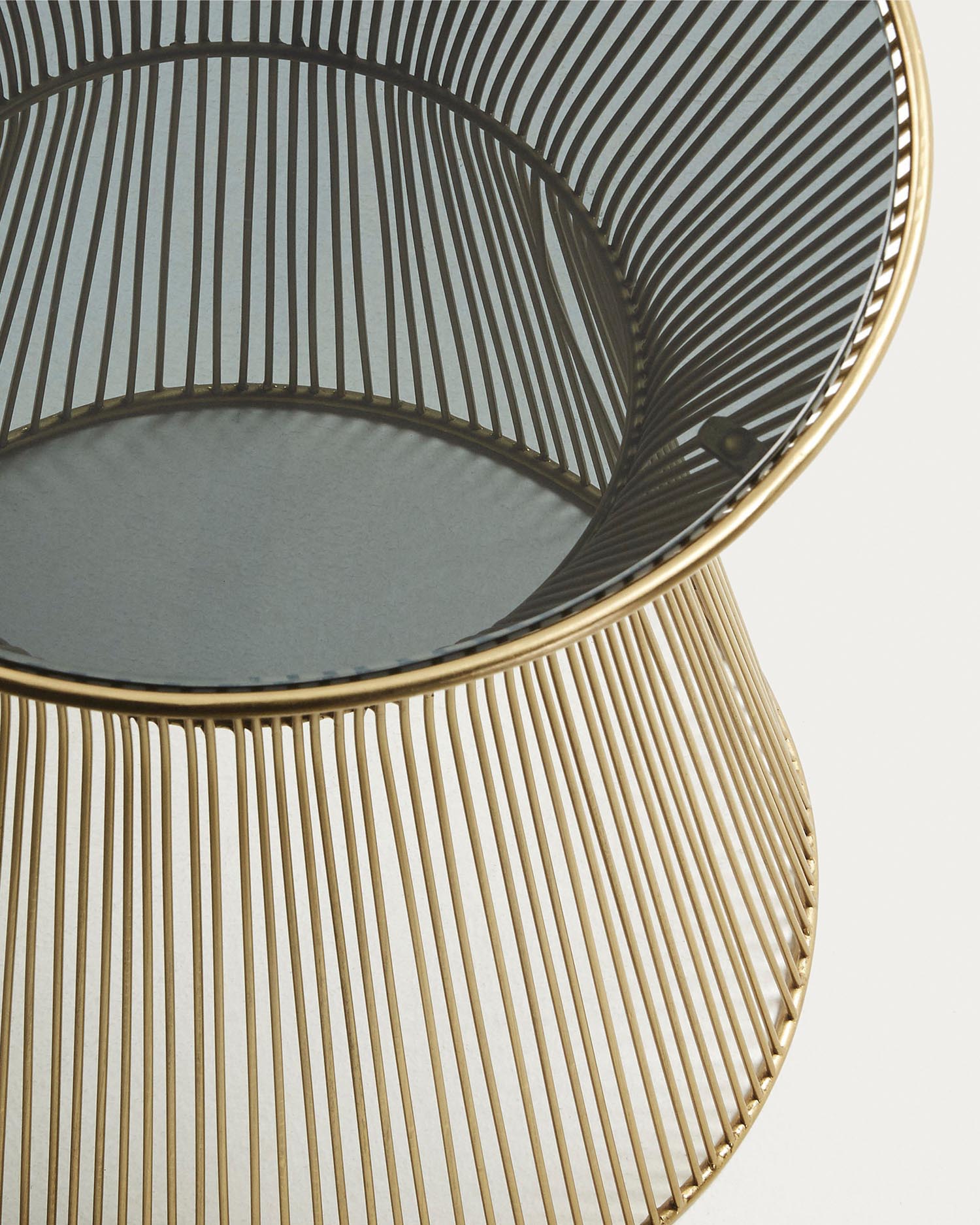Der Jolene Beistelltisch von Kave Home besticht durch seine stilvolle Kombination aus transparenter Glasplatte und luxuriösen goldenen Metallbeinen.