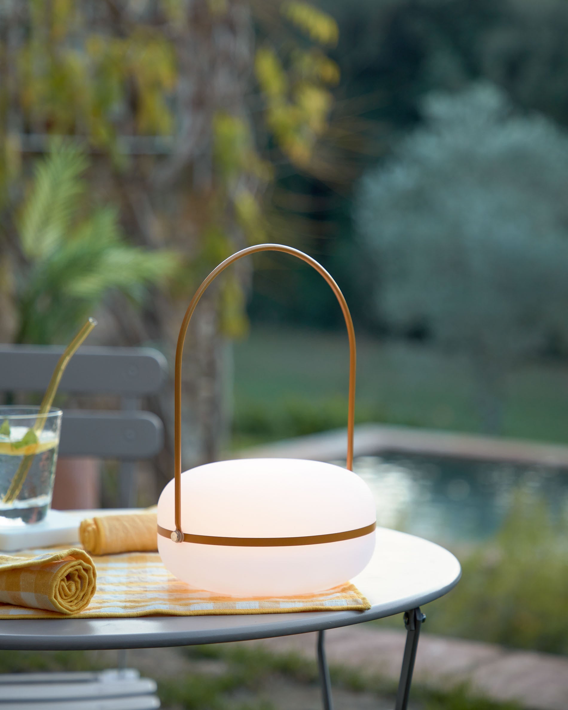 Die Tea Tischlampe von Kave Home kombiniert stilvolles Design mit praktischer Mobilität. Ihr senfgelbes Finish und die robuste Bauweise machen sie zum idealen Lichtakzent für drinnen und draußen.
