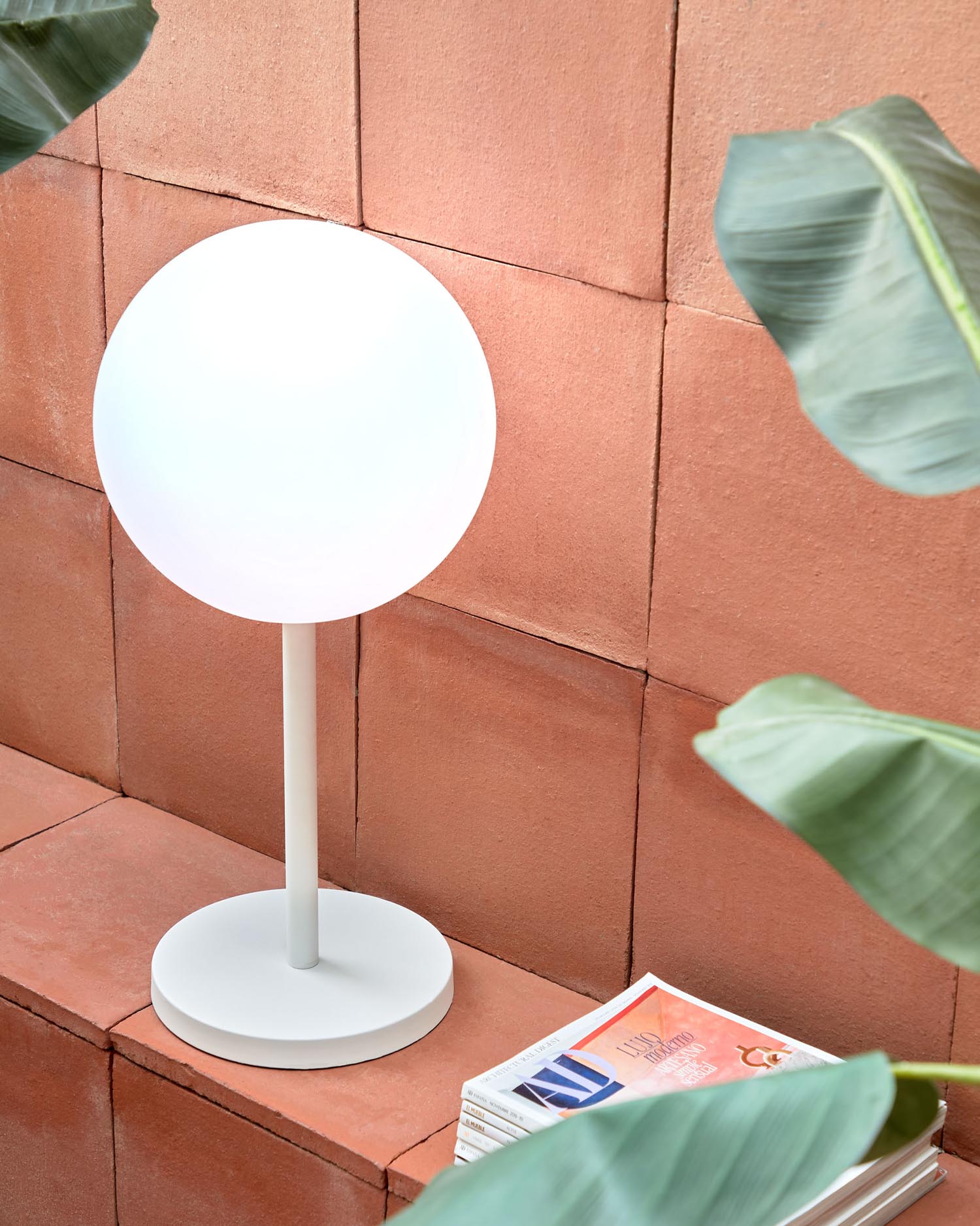 Moderne, tragbare Tischlampe aus robustem, weissem Stahl. Perfekt für stimmungsvolle Beleuchtung im Freien, wetterbeständig und flexibel einsetzbar.