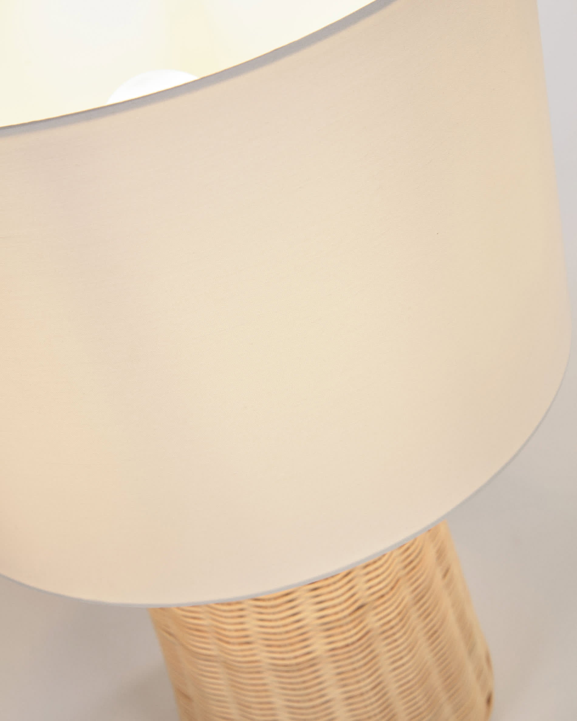 Die Kimjit Tischlampe aus Rattan von Kave Home bringt mit ihrem natürlichen Look und warmem Licht eine einladende Stimmung in Ihr Zuhause.