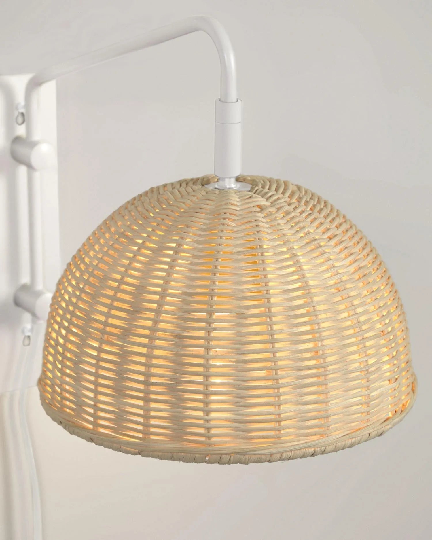 Elegante Wandlampe aus weißem Metall und handgeflochtenem Rattan, die Wärme und Stil in jeden Raum bringt.