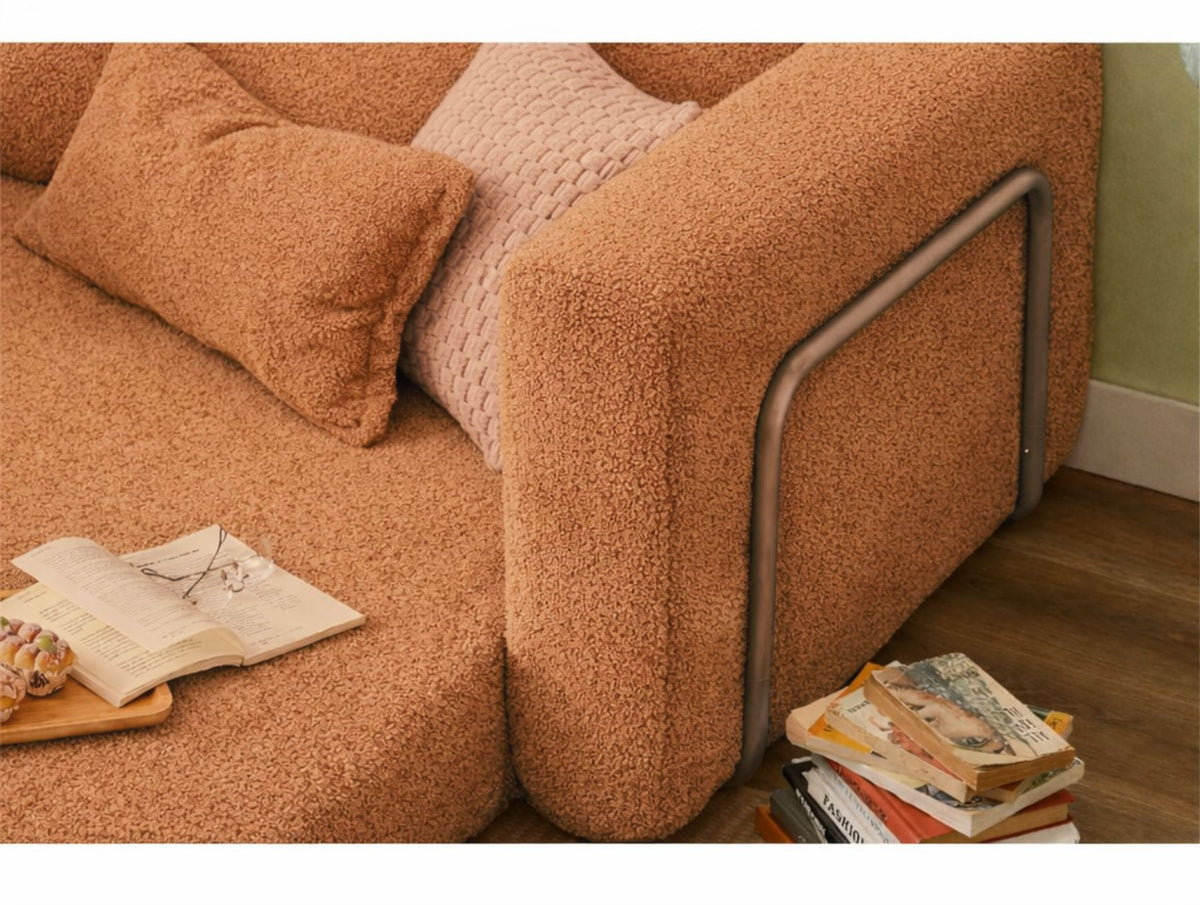 Orangefarbenes 1-Sitzer Schlafsofa aus Bouclé-Stoff mit kompakter Form, sichtbaren Füssen und leicht texturierter, flauschiger Oberfläche.