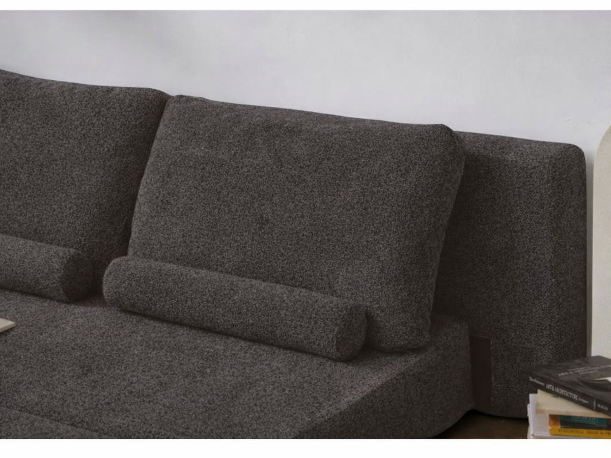 Anthrazitfarbenes 2-Sitzer Schlafsofa Wello aus Bouclé-Stoff mit kompakter Form, Armlehnen und flacher Sitzfläche, aufgestellt im Wohnraum.
