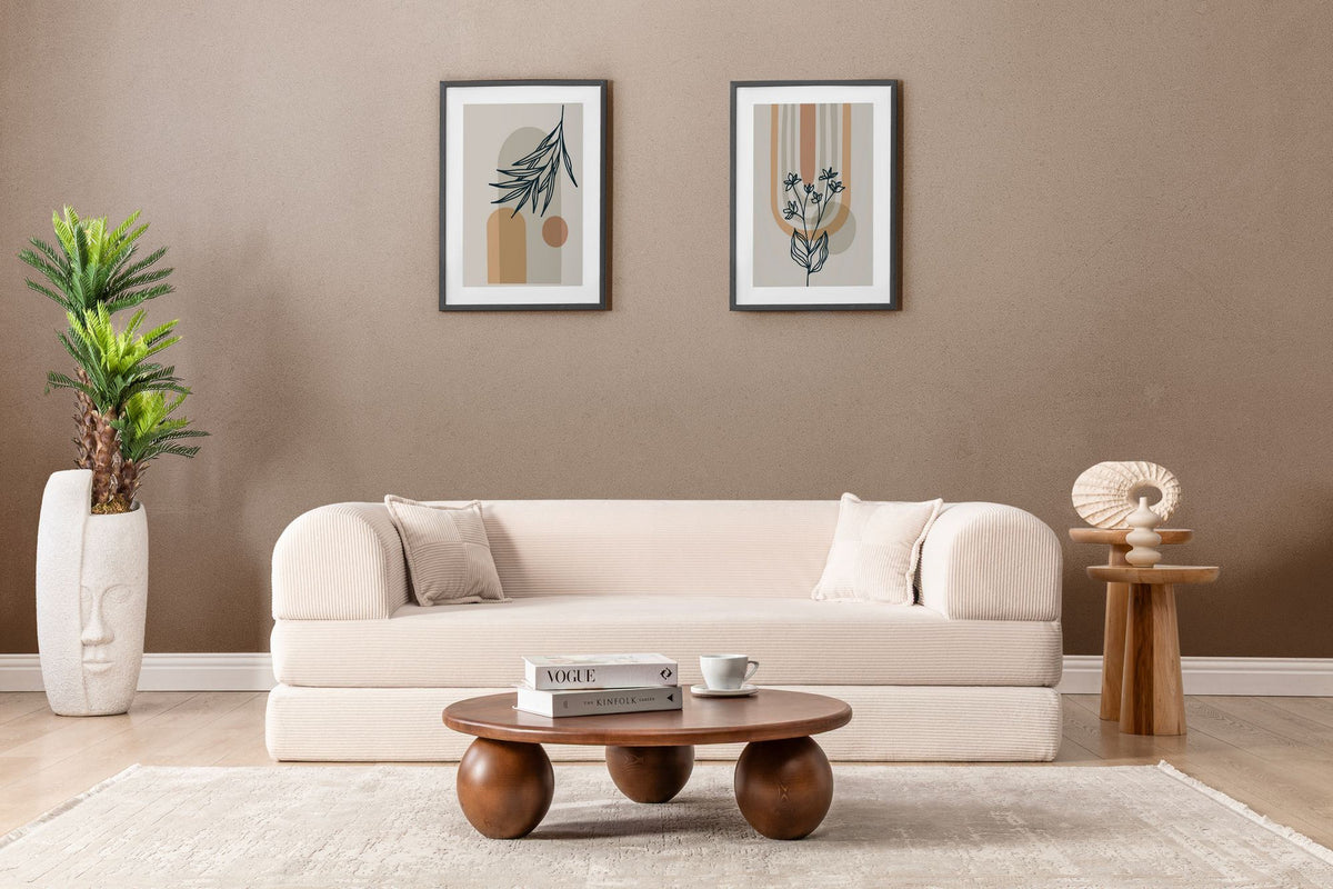 Cremefarbenes 3-Sitzer Schlafsofa Legom Eco von Hanah Home aus geripptem Cord-Plüschstoff mit zwei Kissen im Roll-Pack-Design abgebildet.