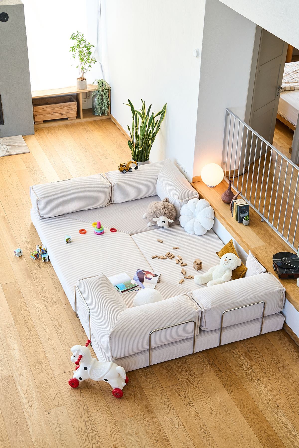 Cremefarbenes Eck-Schlafsofa aus Cord-Plüschstoff mit vier Kissen, rutschfester Sohle und abnehmbarem Bezug, Frontalansicht auf hellem Untergrund.