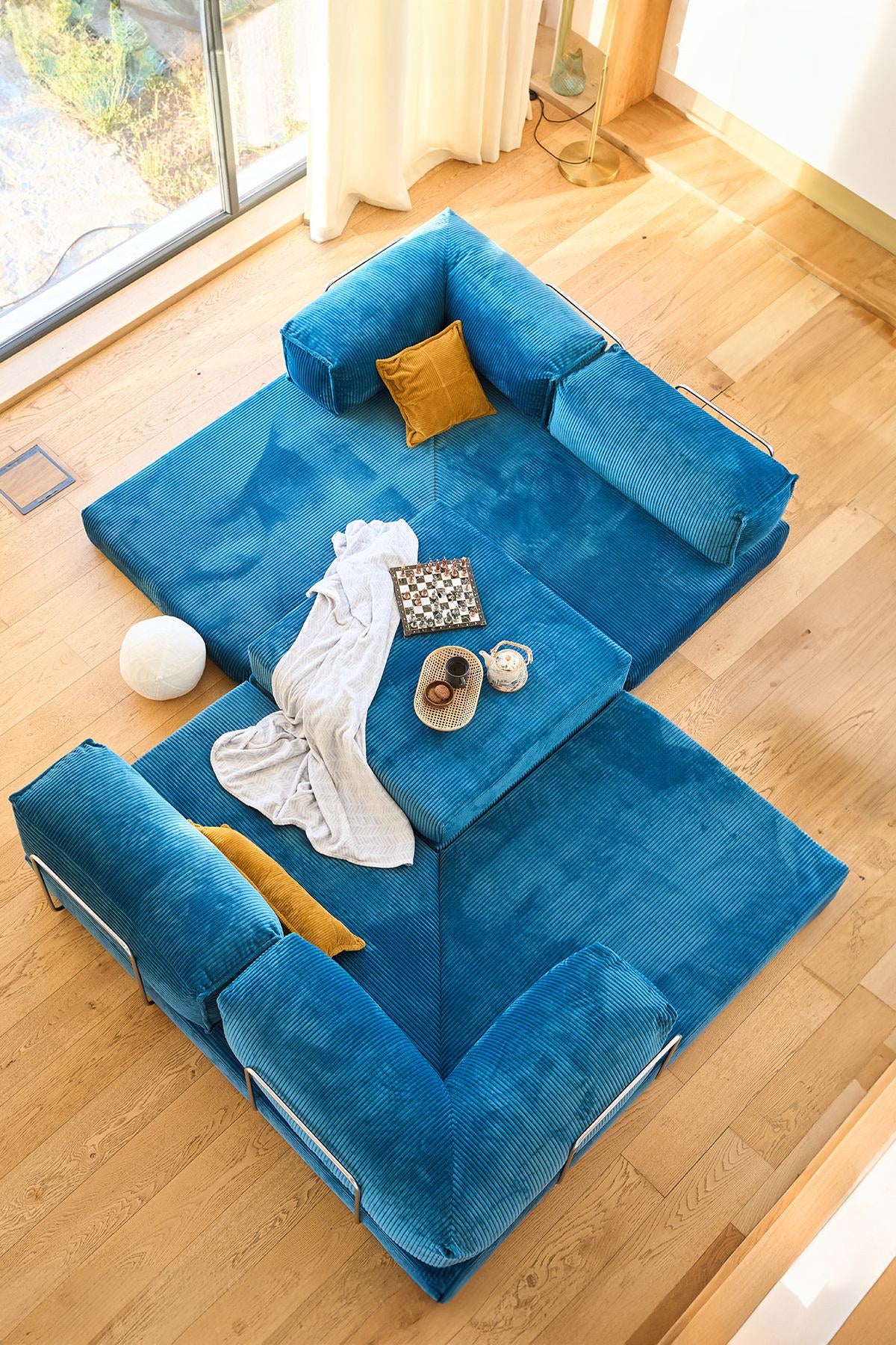 Kanyon Eck-Schlafsofa in Indigo von Hanah Home aus geripptem Cord-Plüschstoff, L-Form mit vier mitgelieferten Kissen.