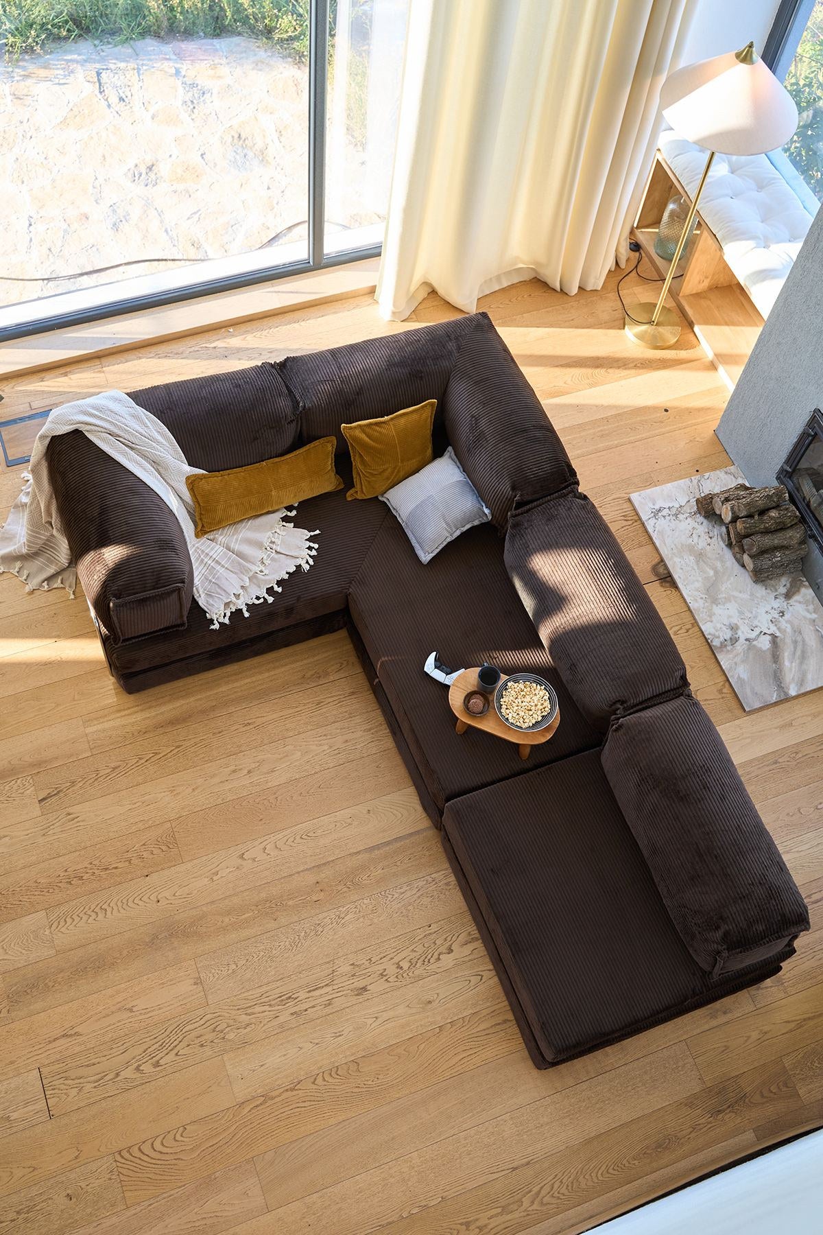 Braunes Eck-Schlafsofa aus Cord-Plüschstoff mit vier Kissen, rutschfester Sohle und abnehmbarem Bezug, Frontalansicht.