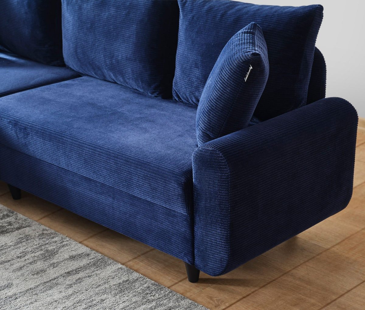 Marineblaues Ecksofa Flavia von Hanah Home mit Metallgestell, Polyesterbezug in Leinenstruktur und Kunststoffbeinen im Wohnraum.