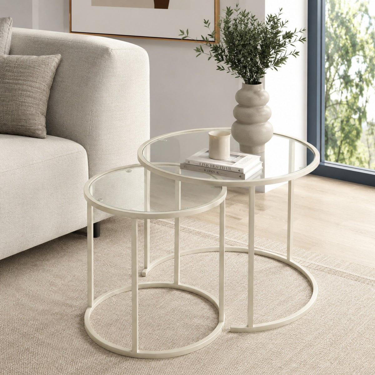 Zwei quadratische Couchtische in Beige mit Glasplatten aus gehärtetem Glas und schlankem Metallgestell, unterschiedliche Grössen.