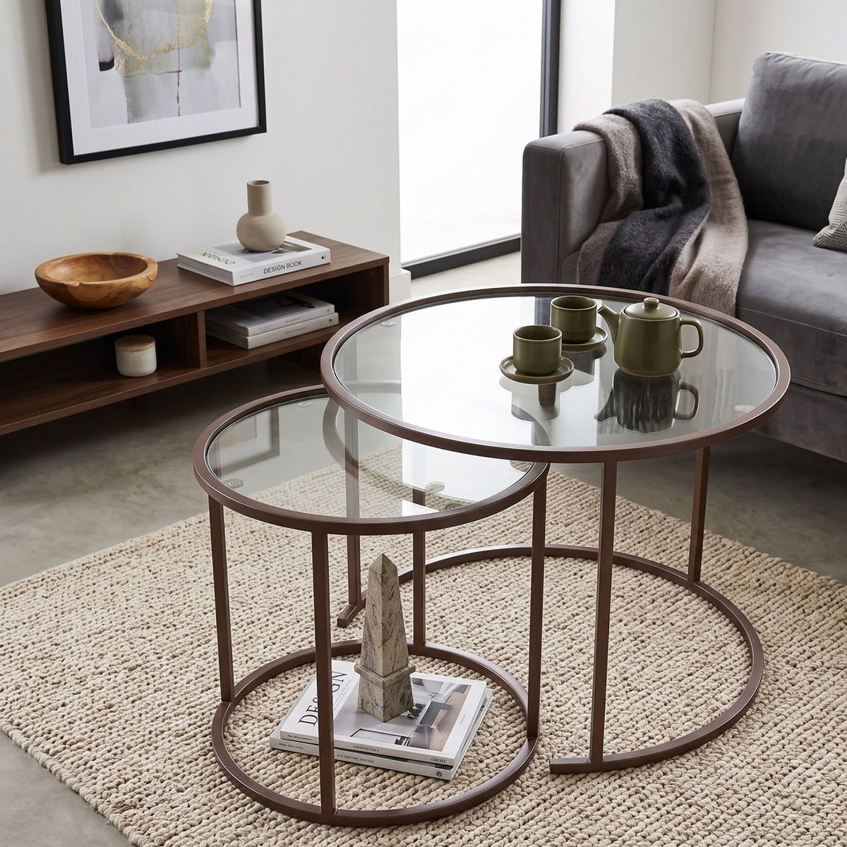 Zwei runde Couchtische aus gehärtetem Glas mit braunem Metallgestell, unterschiedliche Grössen, schlichtes nordisches Design im Wohnzimmer.