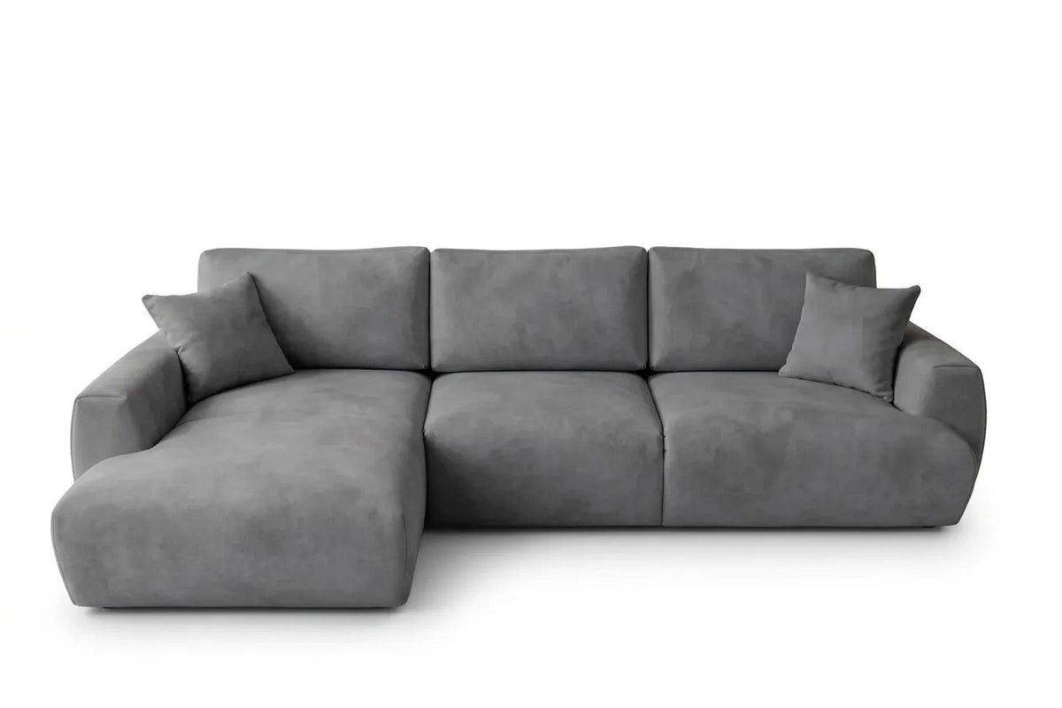 Graues Ecksofa Arthur mit Schlaffunktion, Gestell aus Buchenholz und Spanplatte, Bezug aus Polyester, Kunststoffbeine, zwei Kissen sichtbar.