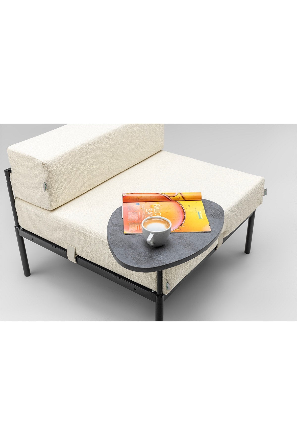 1-Sitzer-Modul von Hanah Home in Schwarz/Creme mit Bouclé-Stoffbezug, Metallgestell, Metallbeinen und gepolsterter Rückenlehne im Wohnraum.