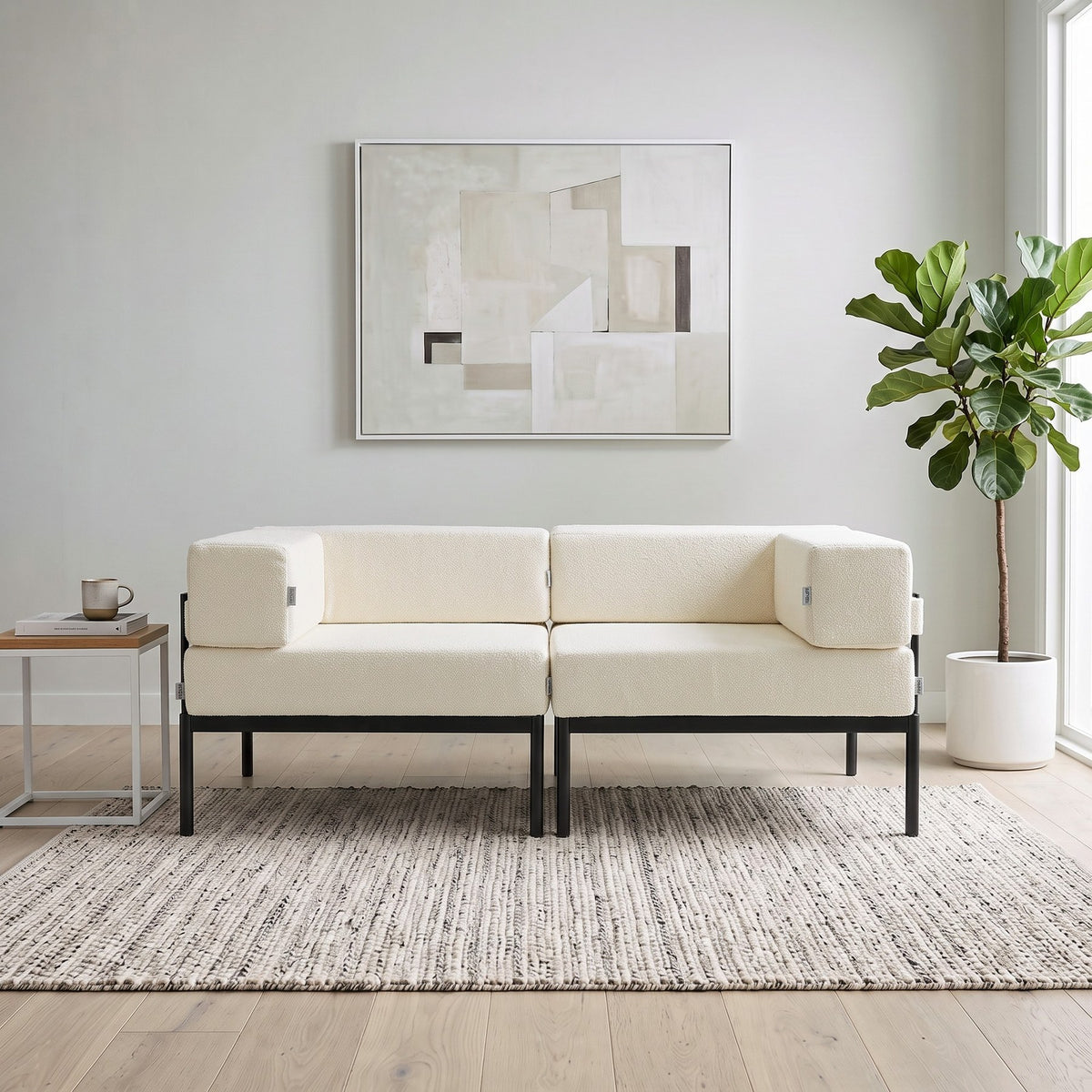 2-Sitzer-Sofa in Schwarz und Creme mit Bouclé-Stoff, Metallbeinen und abnehmbaren Sitzkissen, Breite 180 cm, Tiefe 90 cm, Höhe 46 cm.