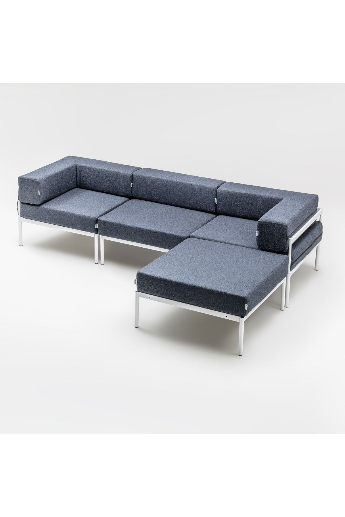 Weisses Ecksofa mit marineblauen Elementen, Bouclé-Stoff, Metallbeine, breite Sitzfläche und verstellbare Rückenlehne im Wohnzimmer.