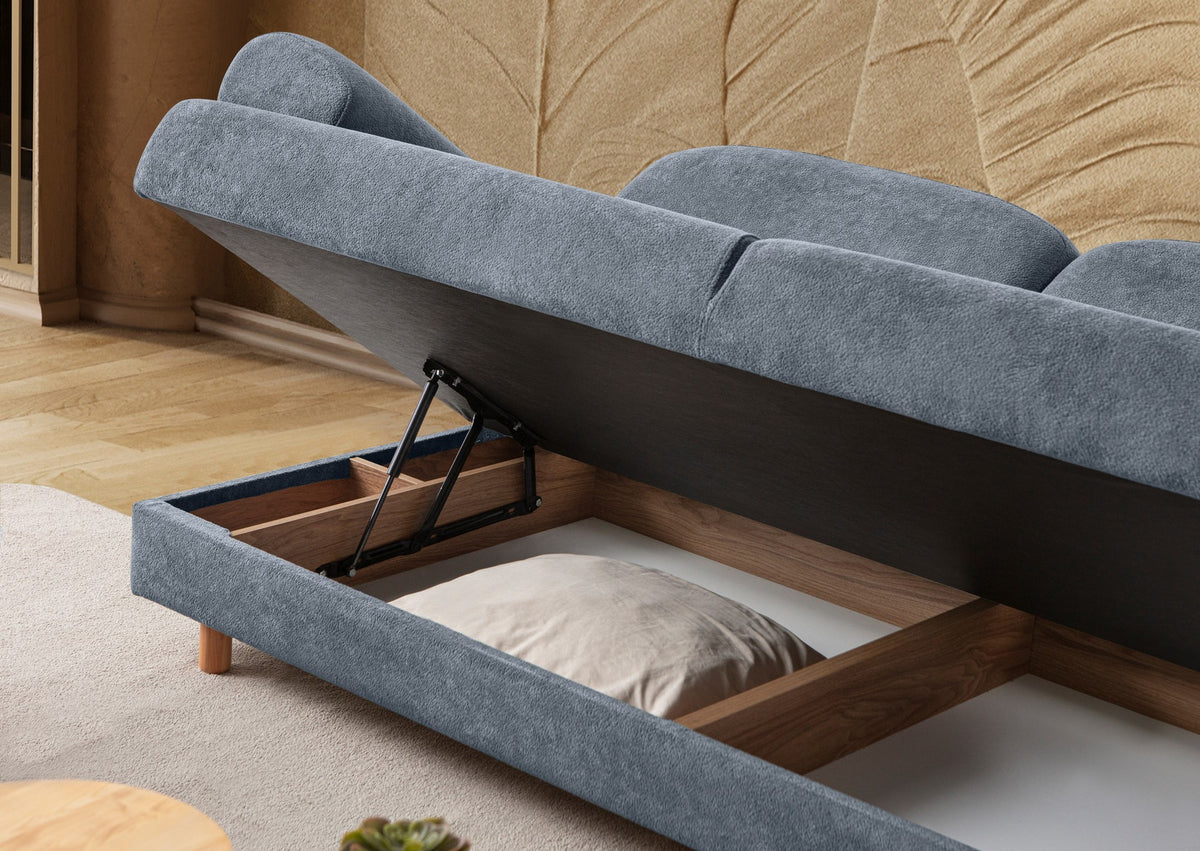 Blaues 3-Sitzer Schlafsofa Aries von Hanah Home mit Coco-Boucle-Stoff, Holzbeinen und drei Kissen, Frontalansicht im Wohnraum.