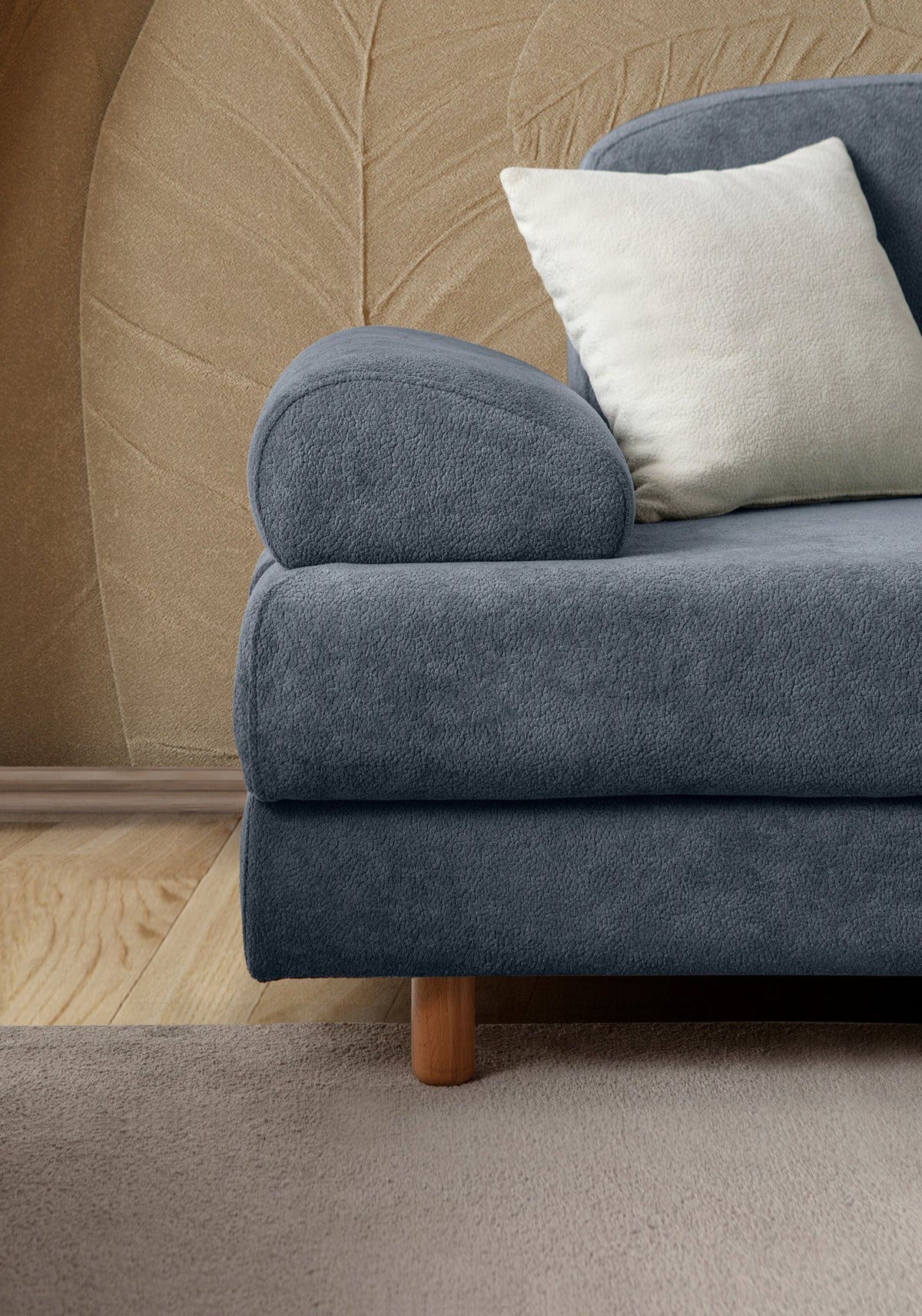 Blaues 3-Sitzer Schlafsofa Aries von Hanah Home mit Coco-Boucle-Stoff, Holzbeinen und drei Kissen, Frontalansicht im Wohnraum.