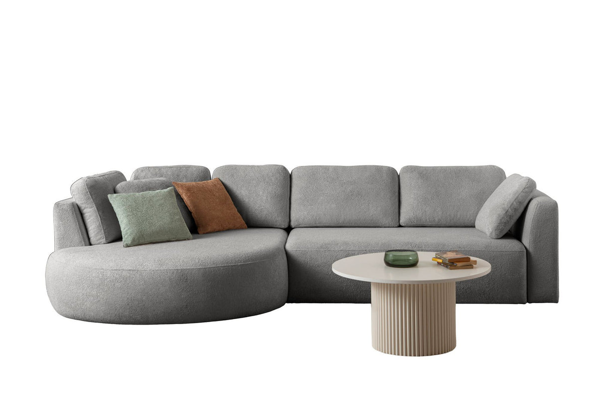 Graues Ecksofa Venezia links von Hanah Home mit Polyesterbezug, Hainbuche-Gestell, Kunststoffbeinen und neun Kissen im Wohnraum.