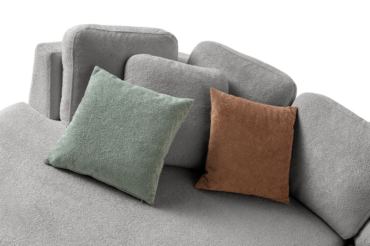 Graues Ecksofa Venezia links von Hanah Home mit Polyesterbezug, Hainbuche-Gestell, Kunststoffbeinen und neun Kissen im Wohnraum.