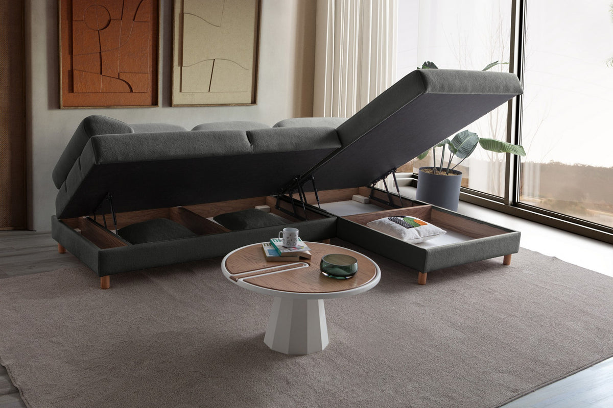 Anthrazitfarbenes Eck-Schlafsofa Aries von Hanah Home mit Coco-Boucle-Bezug, Holzbeinen und ausklappbarer Liegefläche in Wohnraumumgebung.