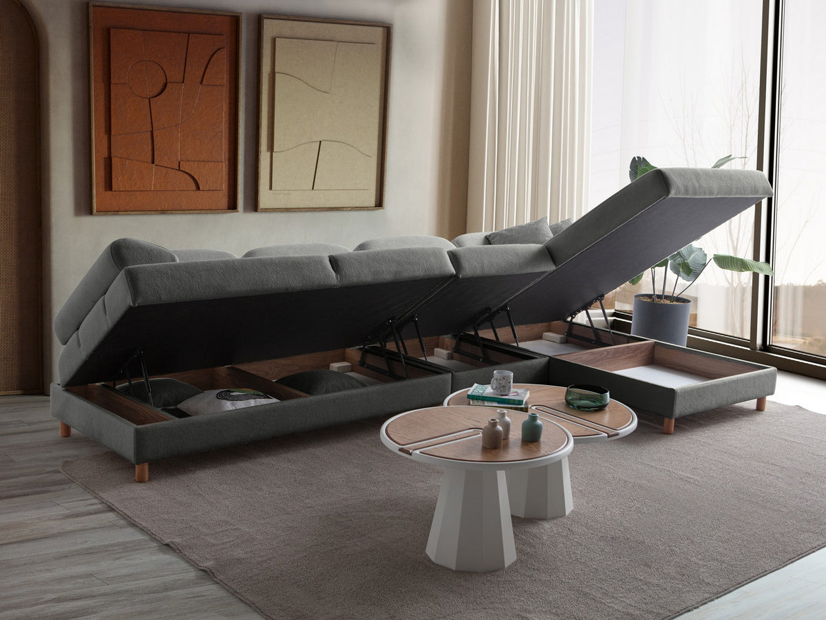Anthrazitfarbenes Eck-Schlafsofa mit Coco-Boucle-Stoffbezug, Holzbeinen und rechter Truhe, fotografiert freistehend im Raum.