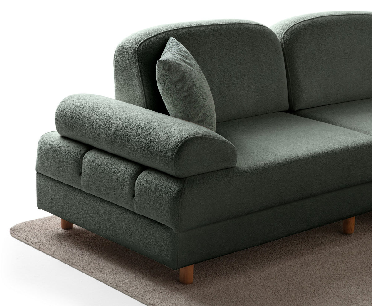 Grünes Eck-Schlafsofa Aries Modular M von Hanah Home mit Coco-Boucle-Polyesterbezug, Holzbeinen und sechs Zierkissen im Wohnzimmer.