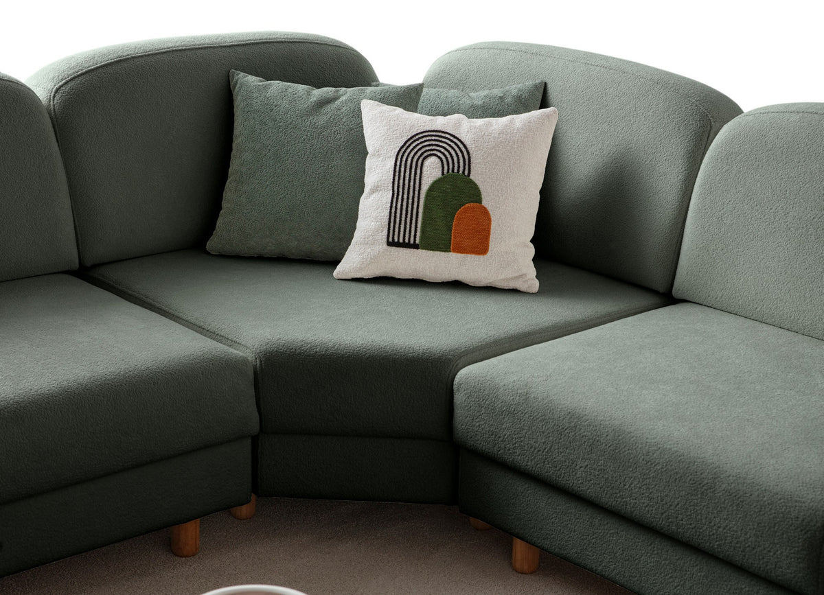 Grünes Eck-Schlafsofa Aries Modular M von Hanah Home mit Coco-Boucle-Polyesterbezug, Holzbeinen und sechs Zierkissen im Wohnzimmer.