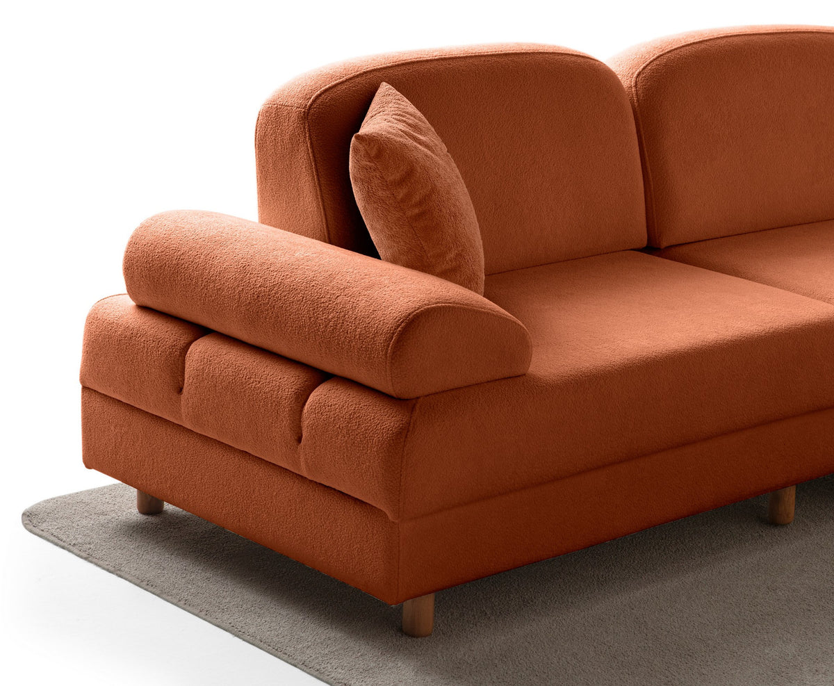 Orangefarbenes Eck-Schlafsofa Aries Modular M mit Coco-Boucle-Stoff, Holzbeinen und sechs Kissen, aufgenommen in einem Wohnraum.