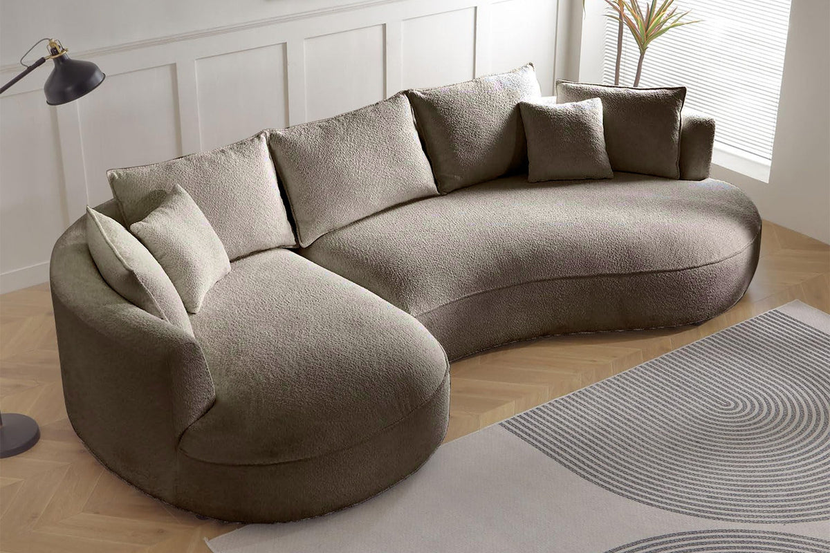 Ecksofa links in Farbe Mink mit Boucle-Stoffbezug, Kunststoffbeinen und sieben Kissen, Grundriss L-Form, Sitztiefe 88 und 124 cm.