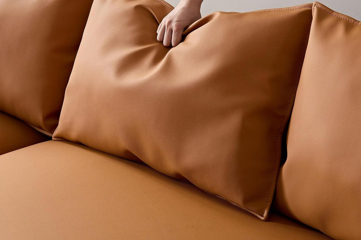 Orangefarbenes Ecksofa Venedik links von Hanah Home mit glattem Kunstlederbezug, Kunststoffbeinen und sieben mitgelieferten Kissen.