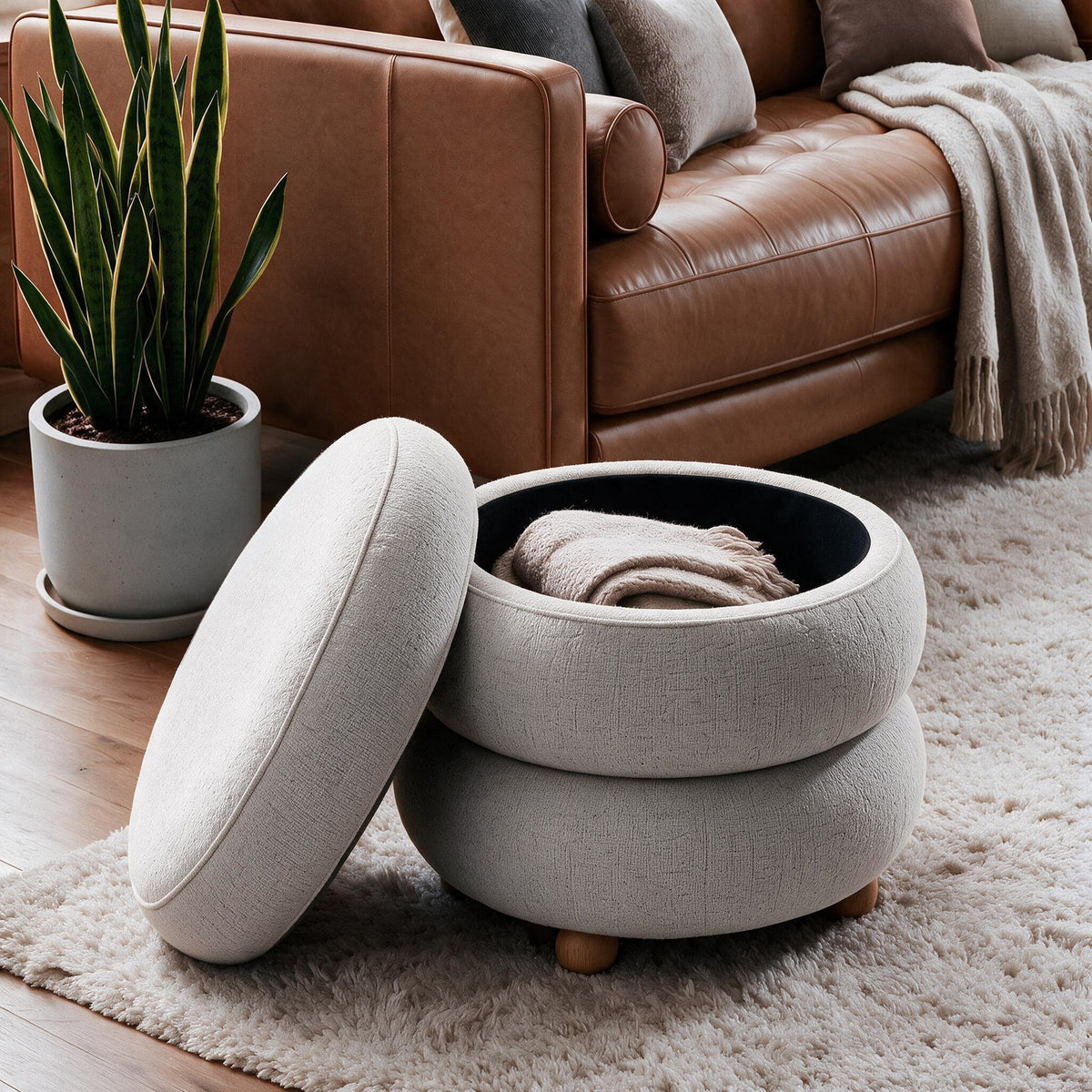 Hellgrauer Ottavia Pouf von Hanah Home mit gestricktem Polyesterbezug, gepolsterter Sitzfläche und Kugelfüssen aus Holz in kompakter Kubusform.
